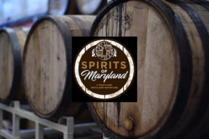 Barrels of wine behind spirits of maryland logo